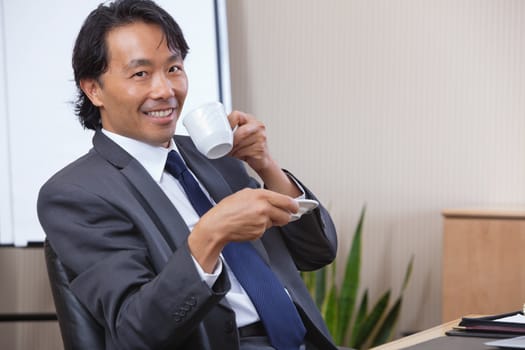 Portrait of smiling businessman having coffee