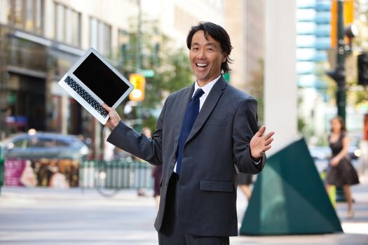 Portrait of successful businessman holding laptop and laughing
