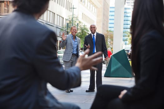 Business people waving and greeting friends on street