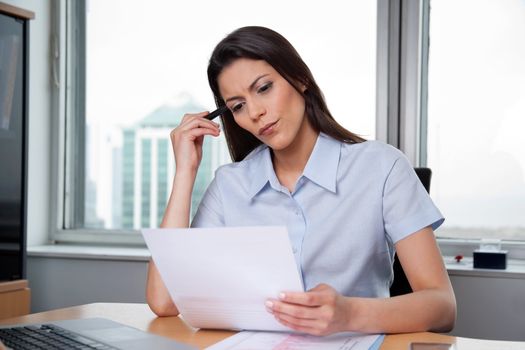 Thoughtful businesswoman reading important business papers