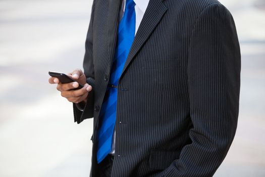 Mid section of business man using cell phone
