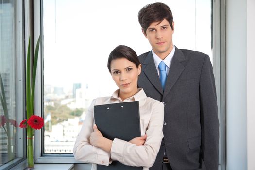Portrait of female executive standing with male executive