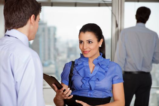 Smiling business woman standing with her colleague in office