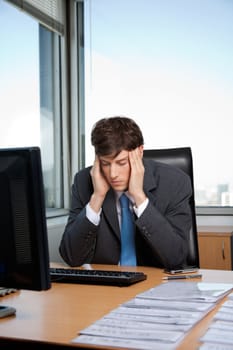 Stressed business manager sitting at his desk