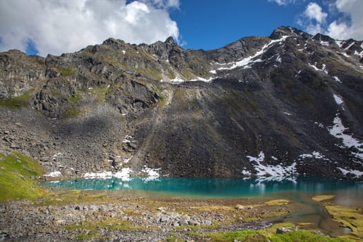 Alpine lake at base of rugged mountain