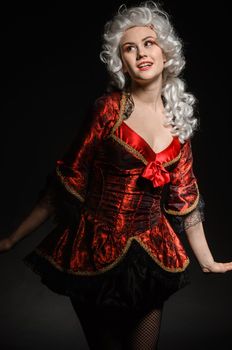 Young woman in baroque costume against dark background