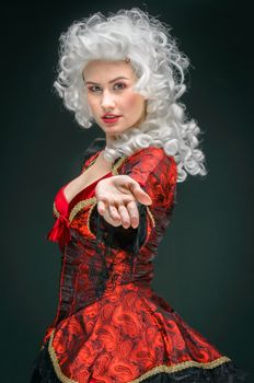 Young woman in baroque costume against dark background