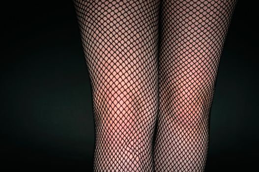 Legs of a youn woman against dark background closeup