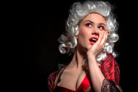 Young woman in baroque costume against dark background