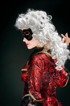 Young woman in baroque custome against dark background