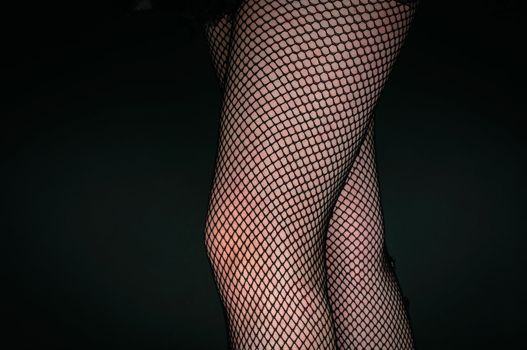 Legs of a youn woman against dark background closeup