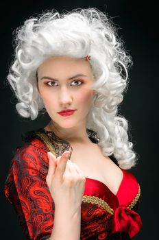 Young woman in baroque costume against dark background