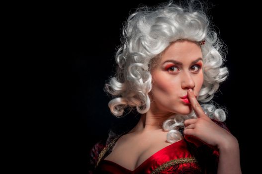 Young woman in baroque custome against dark background