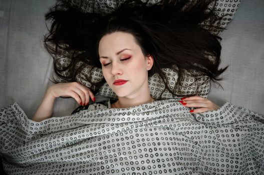 Young woman in the bed in bright light