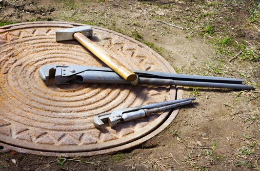 Miscellaneous Tools lies on a rusty manhole cover