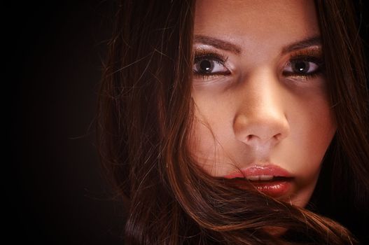 Beautiful young woman against dark background