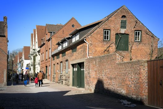 Street with shops, people and homes in Husum in good weather