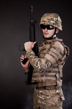 Modern soldier with rifle isolated on a black background