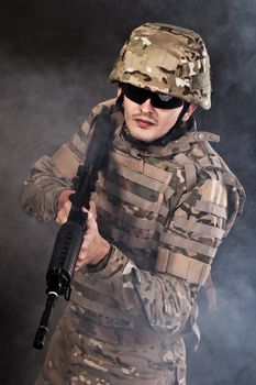 Modern soldier with rifle isolated on a black background