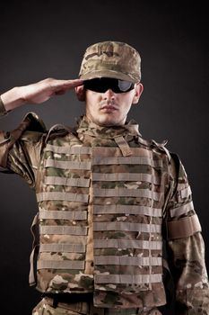 Army soldier saluting. Isolated on a black background