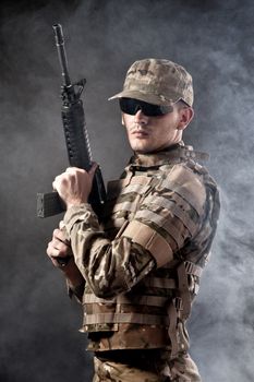 Modern soldier with rifle isolated on a black background