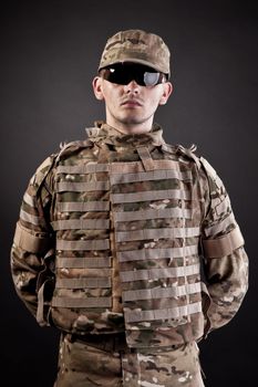 Half length photogaph portrait of adult man in his US Army uniform; copy space on black background