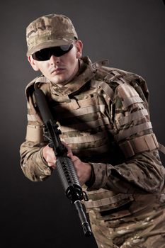 Modern soldier with rifle isolated on a black background