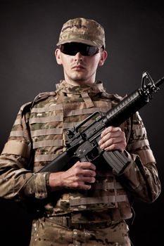 Modern soldier with rifle isolated on a black background