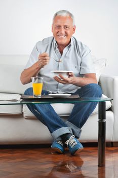 Portrait of happy senior man having breakfast
