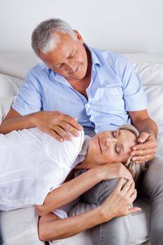Relaxed woman asleep on husband's lap