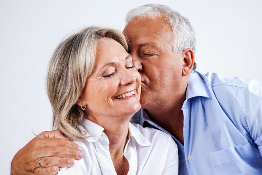 Senior man giving his wife kiss on cheek
