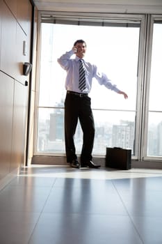 Low angle view of happy young business man talking on cell phone