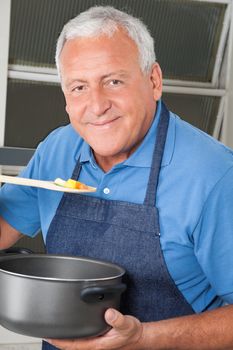 Close-up portrait of senior man tasting food