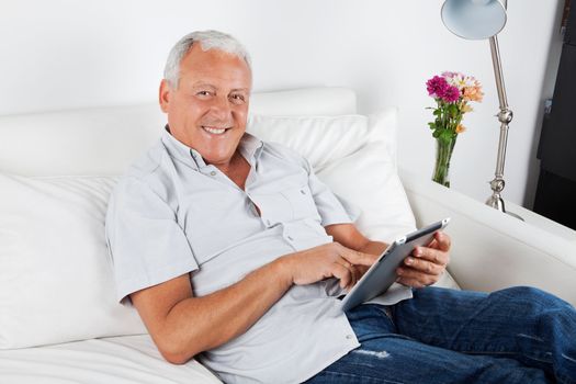 Portrait of smiling senior man using digital tablet PC