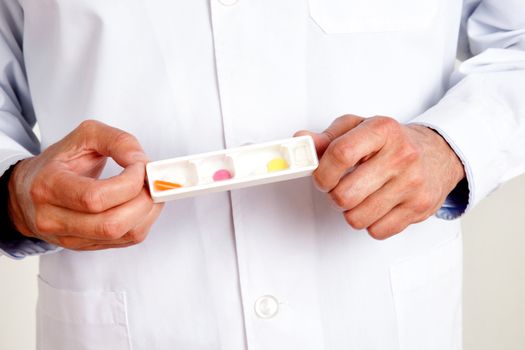 Close-up of male doctor hand holding pills.