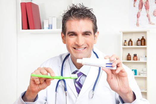 Portrait of male doctor holding tooth brush and toothpaste.