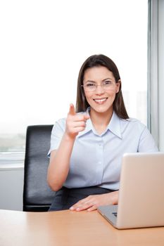 Portrait Of A Young Businesswoman Pointing At The Viewer In Her Office.