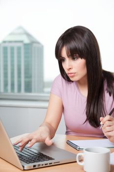 Pretty young business woman at office desk.