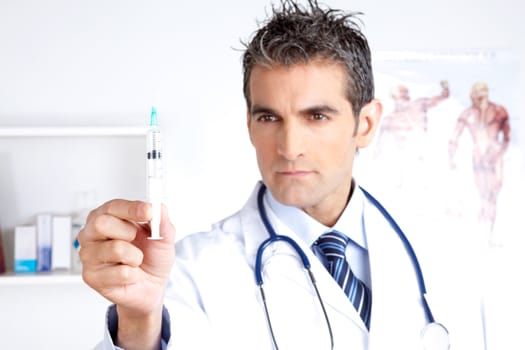 Doctor looking at syringe holding in hand.