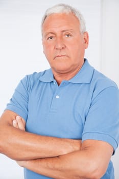 Portrait of serious senior man with arms crossed