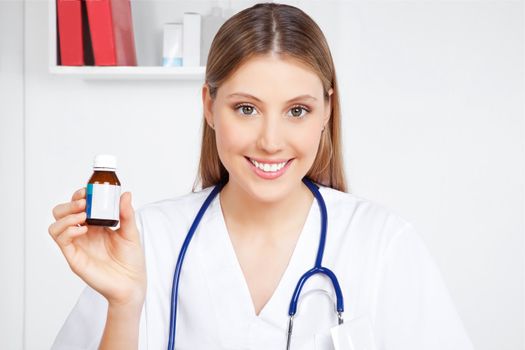 Happy smiling female doctor holding medicine bottle in hand.