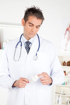 Male doctor holding a bottle of pills.