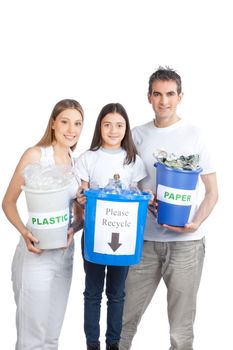 Portrait of happy couple smiling with daughter holding recycle bin.