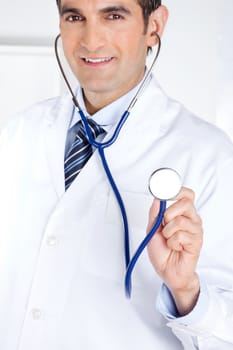 Portrait of male doctor holding stethoscope .