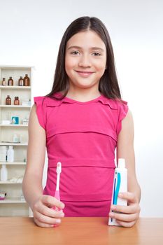 Portrait of girl holding toothbrush and tooth paste.