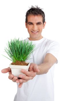 Man holding pot of green plant against white background.