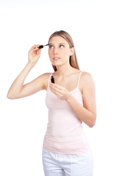 Beautiful woman applying mascara on her eyelashes.