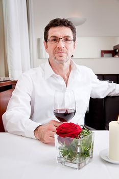 man and woman in restaurant for dinner drinking red wine and smiling