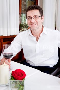 man and woman in restaurant for dinner drinking red wine and smiling