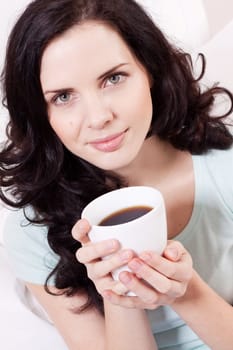 smiling brunette woman drinking black coffee in the morning